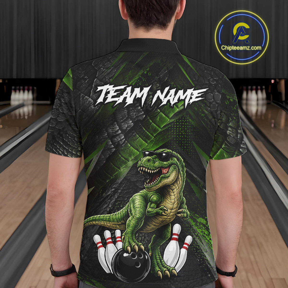 Man wearing bowling polo shirt featuring a dinosaur standing among bowling pins and ball artwork on black green textured background.