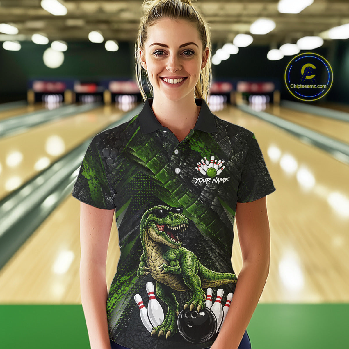 Women wearing bowling polo shirt featuring a dinosaur standing among bowling pins and ball artwork on black green textured background.