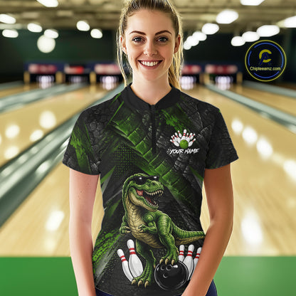Women wearing bowling quarter zip shirt featuring a dinosaur standing among bowling pins and ball artwork on black green textured background.