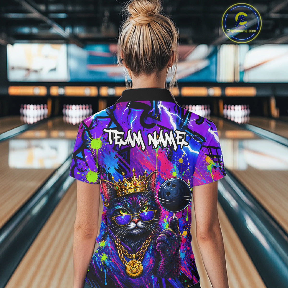 Women wearing personalized bowling quarter zip shirt with a crowned cat holding a bowling ball, blended with colorful paint strokes and graphic patterns.