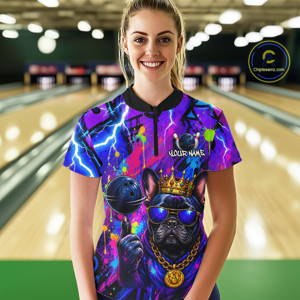 Women wearing personalized bowling quarter zip shirt with a crowned bulldog holding a bowling ball, surrounded by paint effects and bold graphic patterns.