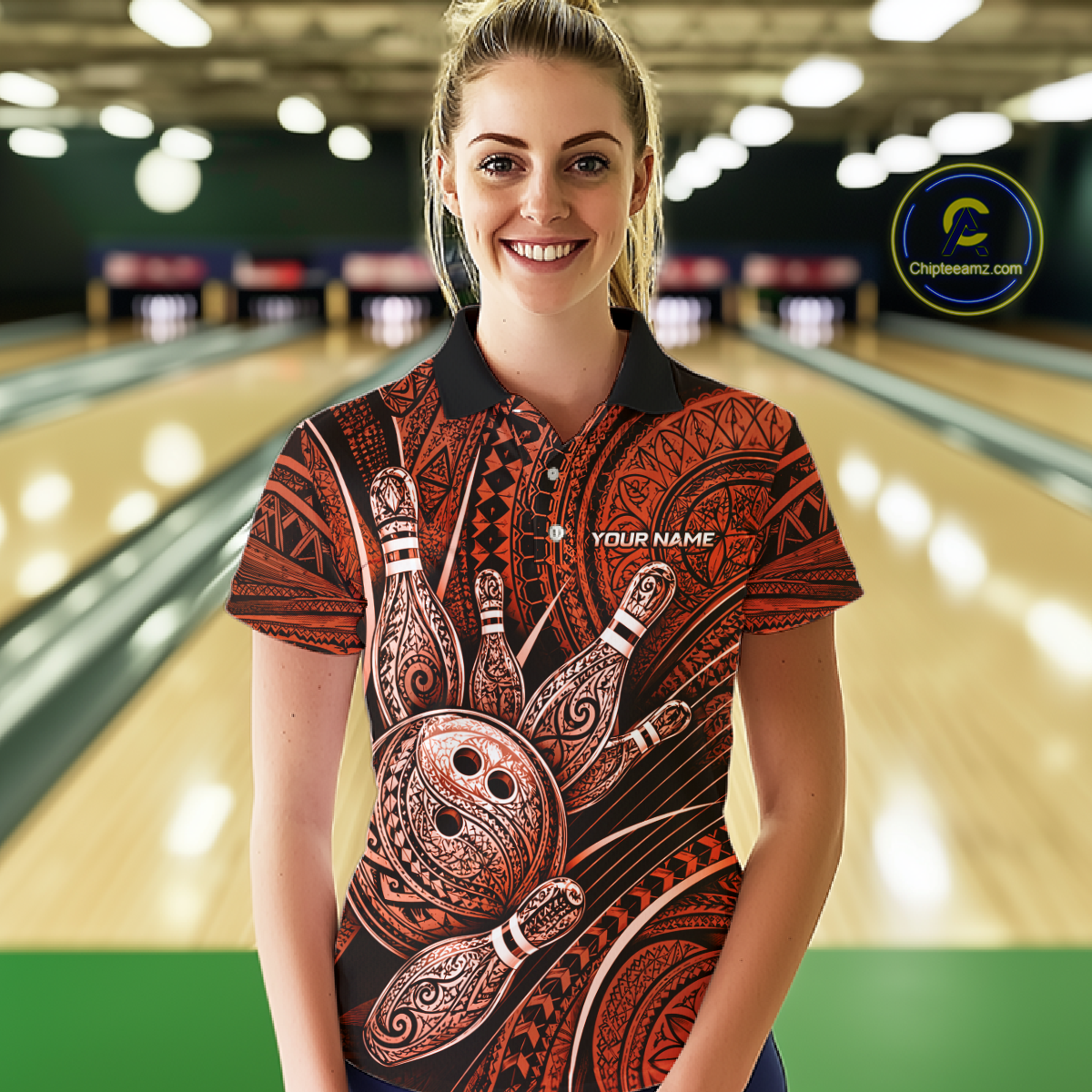 A woman stands in a bowling alley wearing a short-sleeve collared bowling shirt with a red, black, and brown tribal-inspired bowling pin graphic print. The shirt features a black collar, a black button placket, and a white 'YOUR NAME' placeholder on the chest.