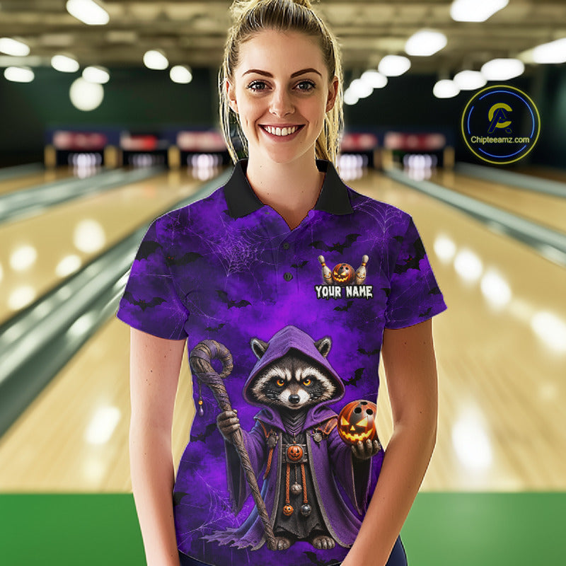 A woman stands in a bowling alley wearing a custom purple and black polo shirt with a cartoon raccoon dressed as a wizard holding a bowling ball. The shirt features a 'YOUR NAME' customization placeholder on the chest.