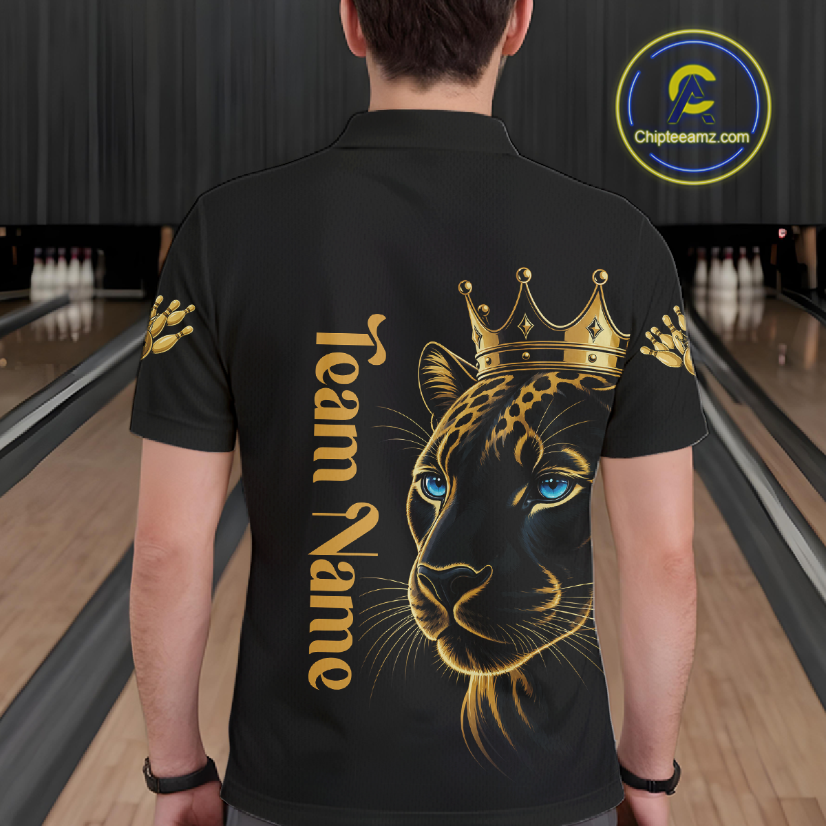 Person wearing a black t-shirt with a gold leopard design and 'Team Name' text in a bowling alley.