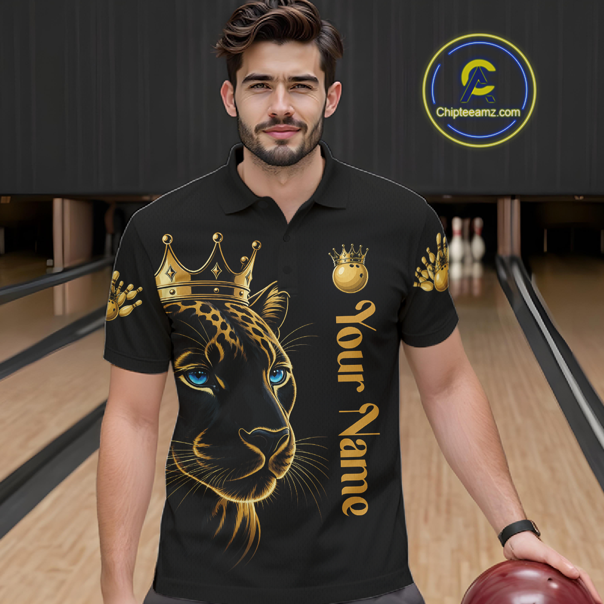 Man wearing a black polo shirt with a gold and black panther design and 'Your Name' text, holding a bowling ball in a bowling alley.