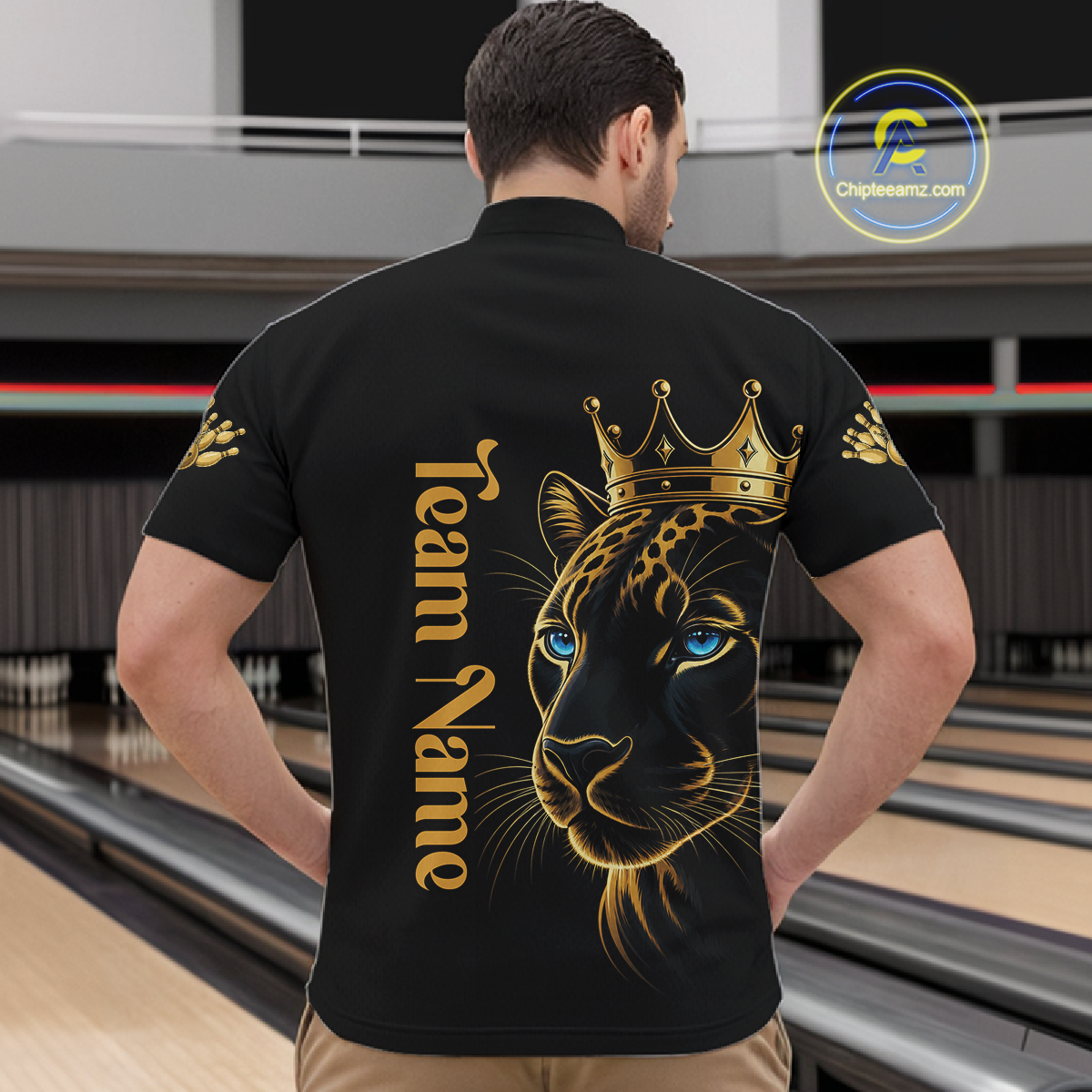 Man wearing a black t-shirt with a gold leopard design and 'Team Name' text at a bowling alley.