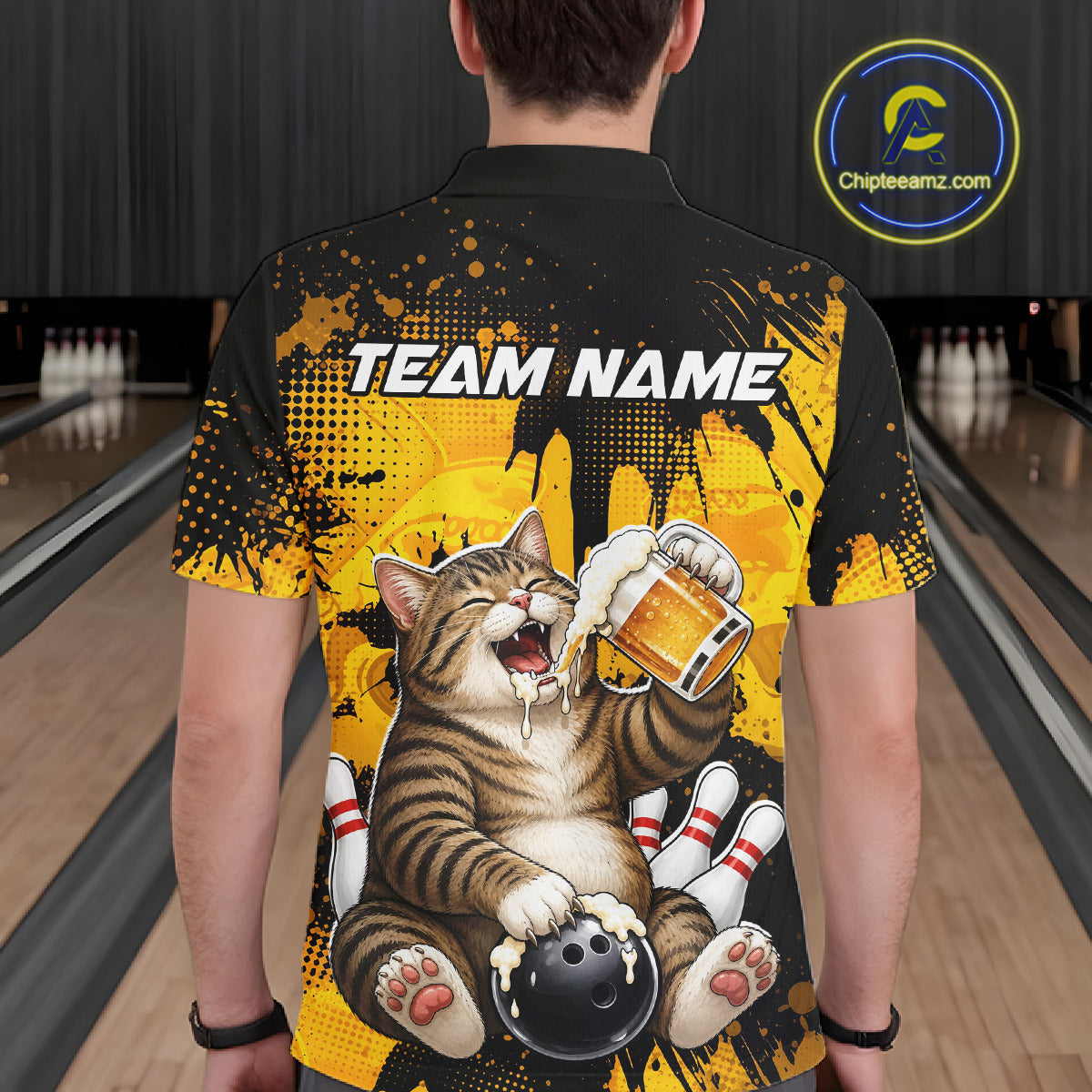 Person wearing a bowling-themed shirt with a cat design in a bowling alley.