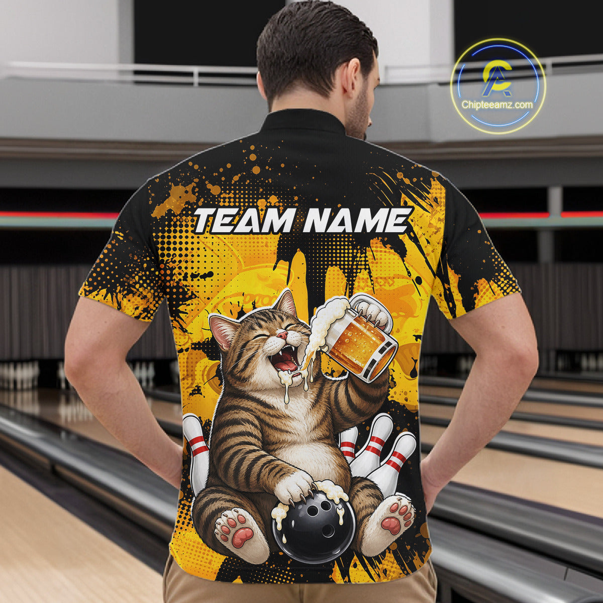 Person wearing a bowling-themed shirt with a cat design in a bowling alley.