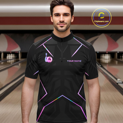 Man wearing a black bowling shirt with colorful designs in a bowling alley.