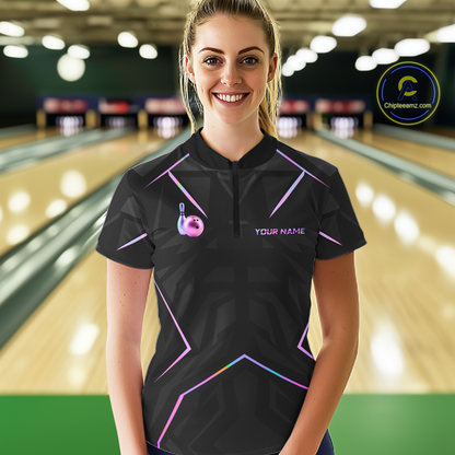 Woman wearing a black bowling shirt with colorful designs and 'Your Name' text in a bowling alley.