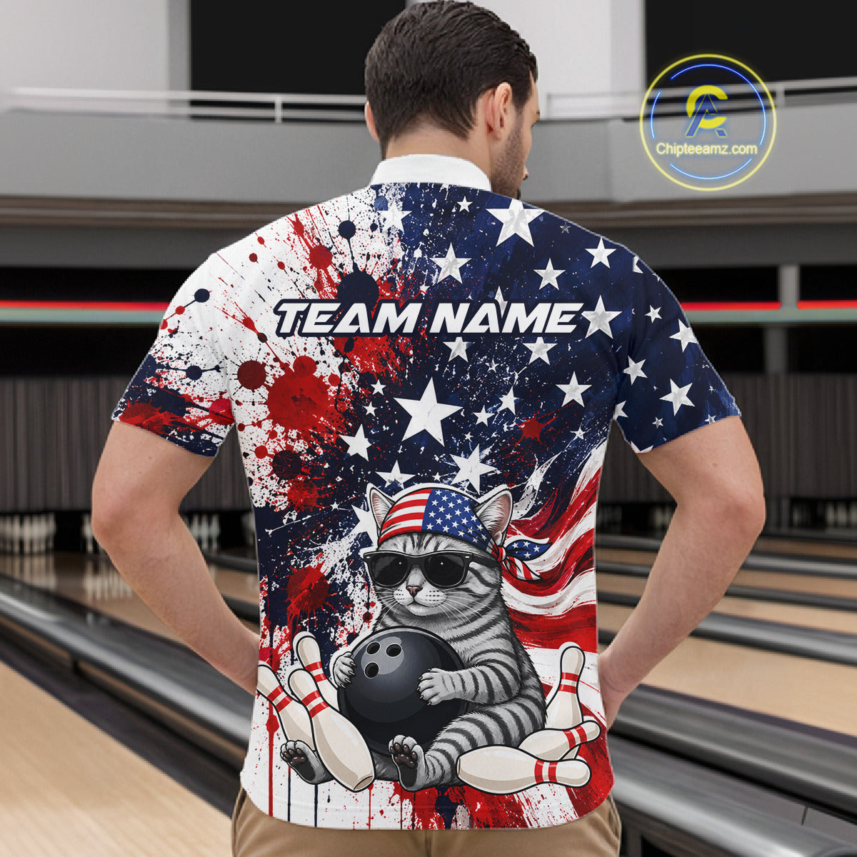 Man wearing a bowling-themed shirt with American flag design in a bowling alley.