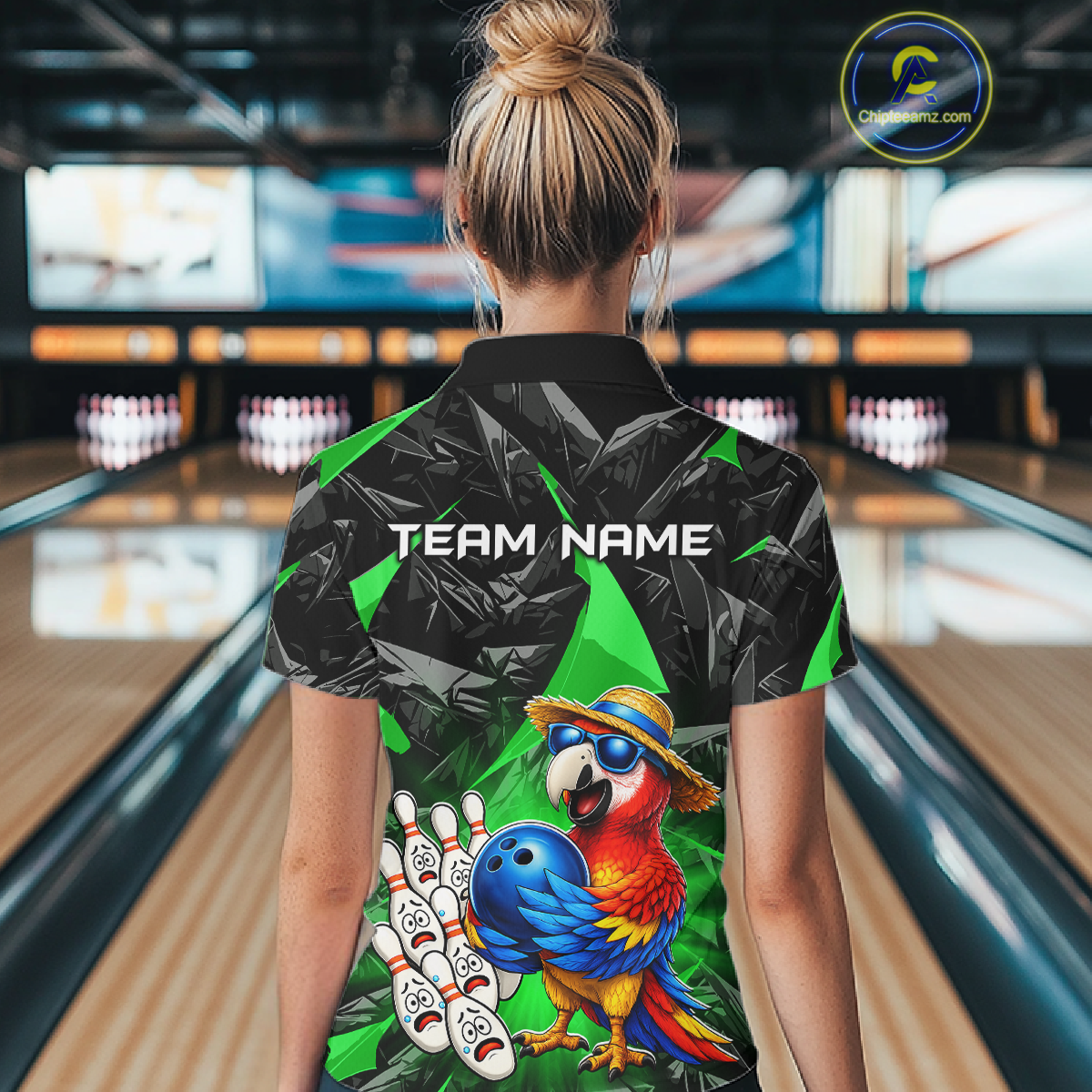 Person wearing a colorful bowling shirt with a parrot design in a bowling alley.