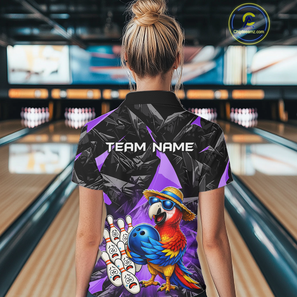 Person wearing a colorful bowling shirt with a parrot design in a bowling alley.