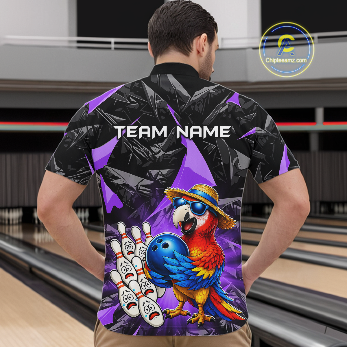 Man wearing a colorful bowling shirt with a parrot design in a bowling alley.