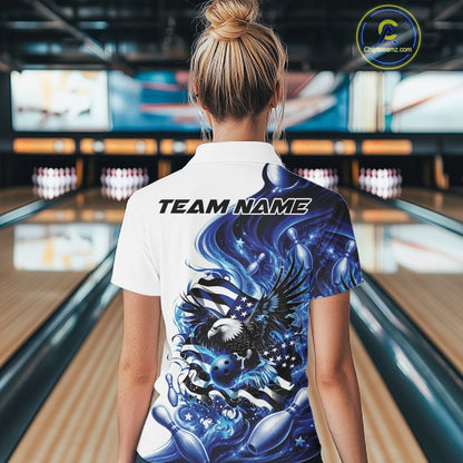 Back view female model at a bowling lane wearing a white and blue polo shirt with eagle graphics, bowling elements, and flowing flag inspired artwork.