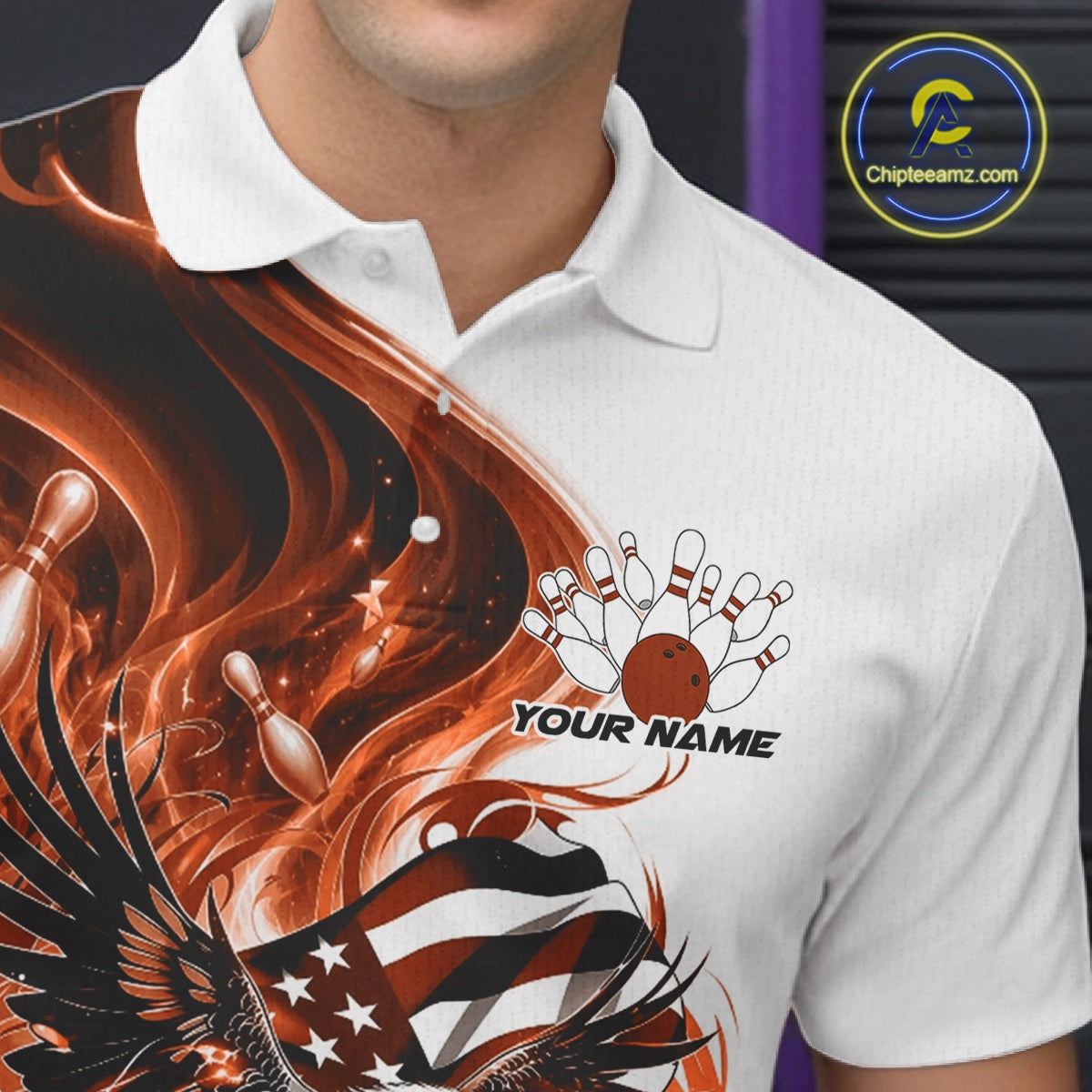 Close up left chest view of a white and orange bowling polo shirt featuring eagle artwork, bowling elements, and flowing American flag inspired graphics.