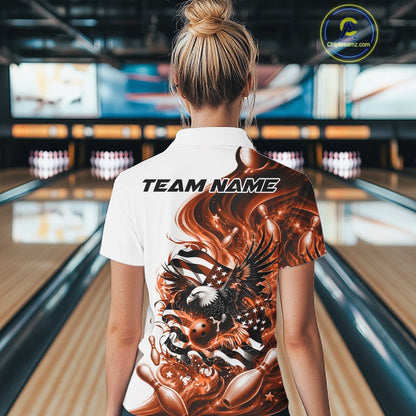 Female model back view in a bowling lane wearing a white and orange polo shirt with eagle artwork and flowing American flag inspired graphics.