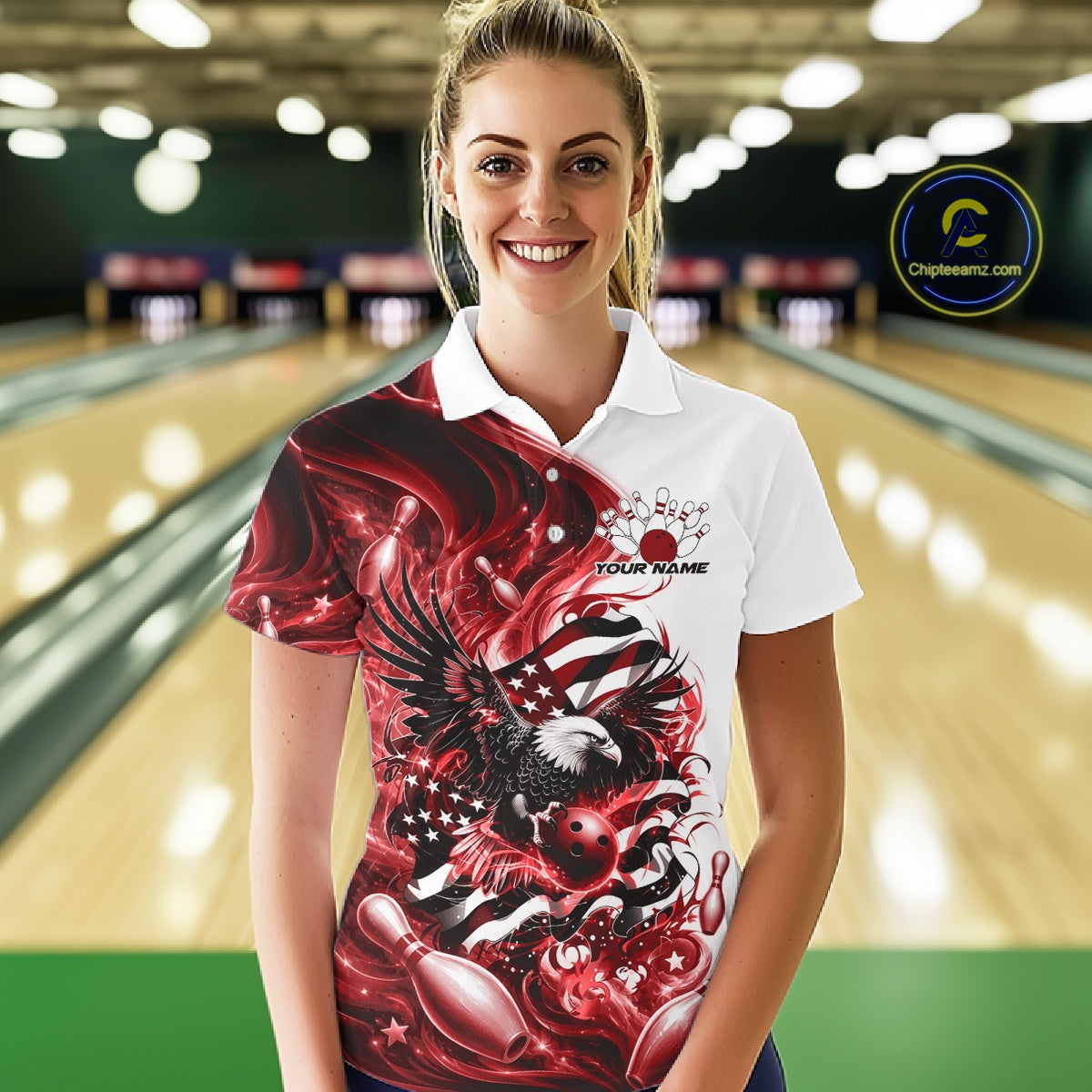 Female model front view in a bowling lane wearing a white and red polo shirt with eagle artwork, bowling elements, and flowing flag inspired graphics.