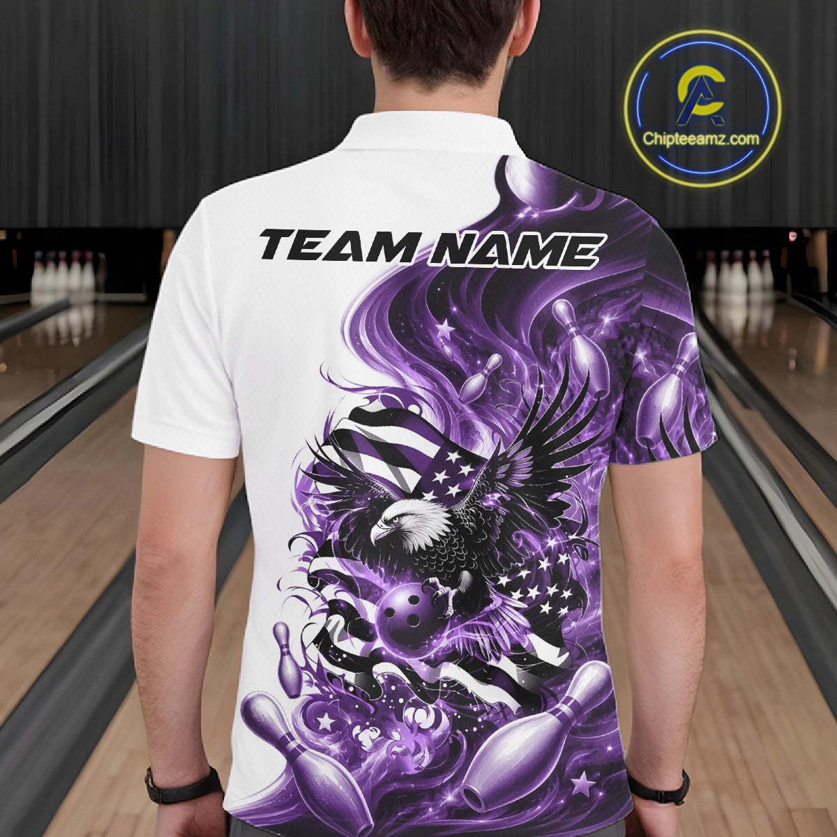 Back view of a male model at a bowling lane wearing a white and purple bowling polo shirt with eagle and flag inspired artwork.
