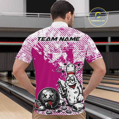 Male model at a bowling lane wearing a pink and white quarter-zip shirt, cartoon drunk bowling pin design holding beer and bowling ball.