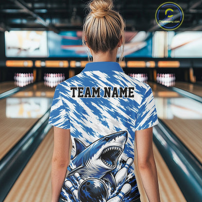 Person wearing a blue and white patterned shirt with a shark design in a bowling alley.