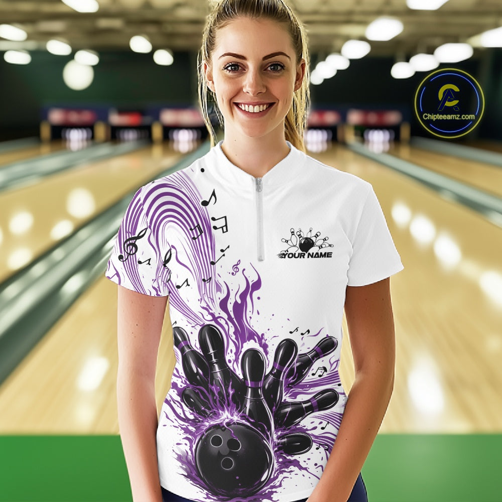 Female model wearing a white and purple bowling quarter-zip shirt at the bowling lane with musical wave graphics and bowling artwork.