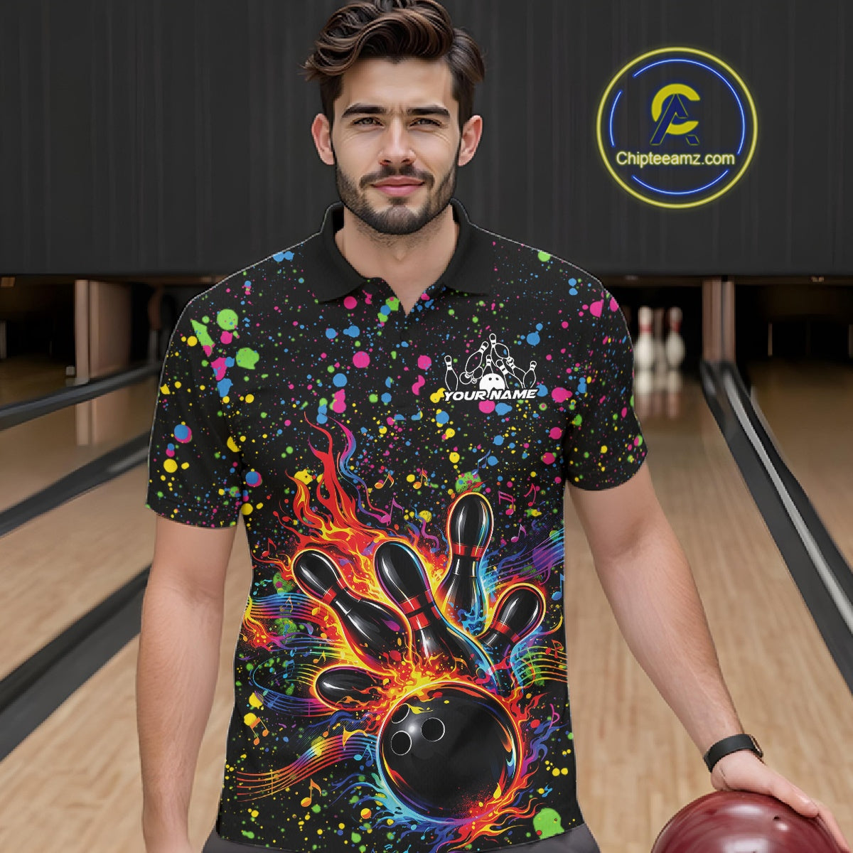 Male model wearing a black bowling polo shirt at the lane with vibrant splatter accents and bowling strike artwork.