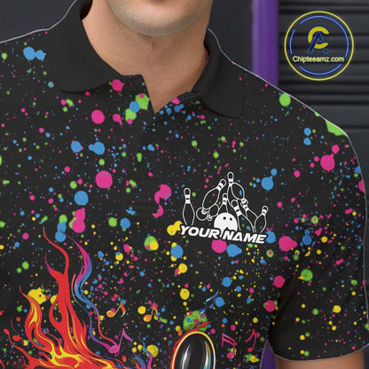 Left chest close-up of a black bowling polo shirt displaying flaming bowling artwork with colorful paint splatters.