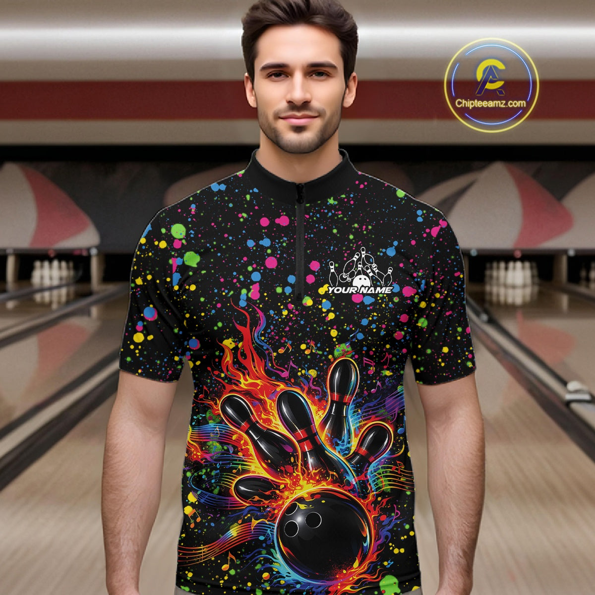 Male model wearing a black bowling quarter-zip shirt at the lane with vibrant music-themed splatters and bowling strike artwork.