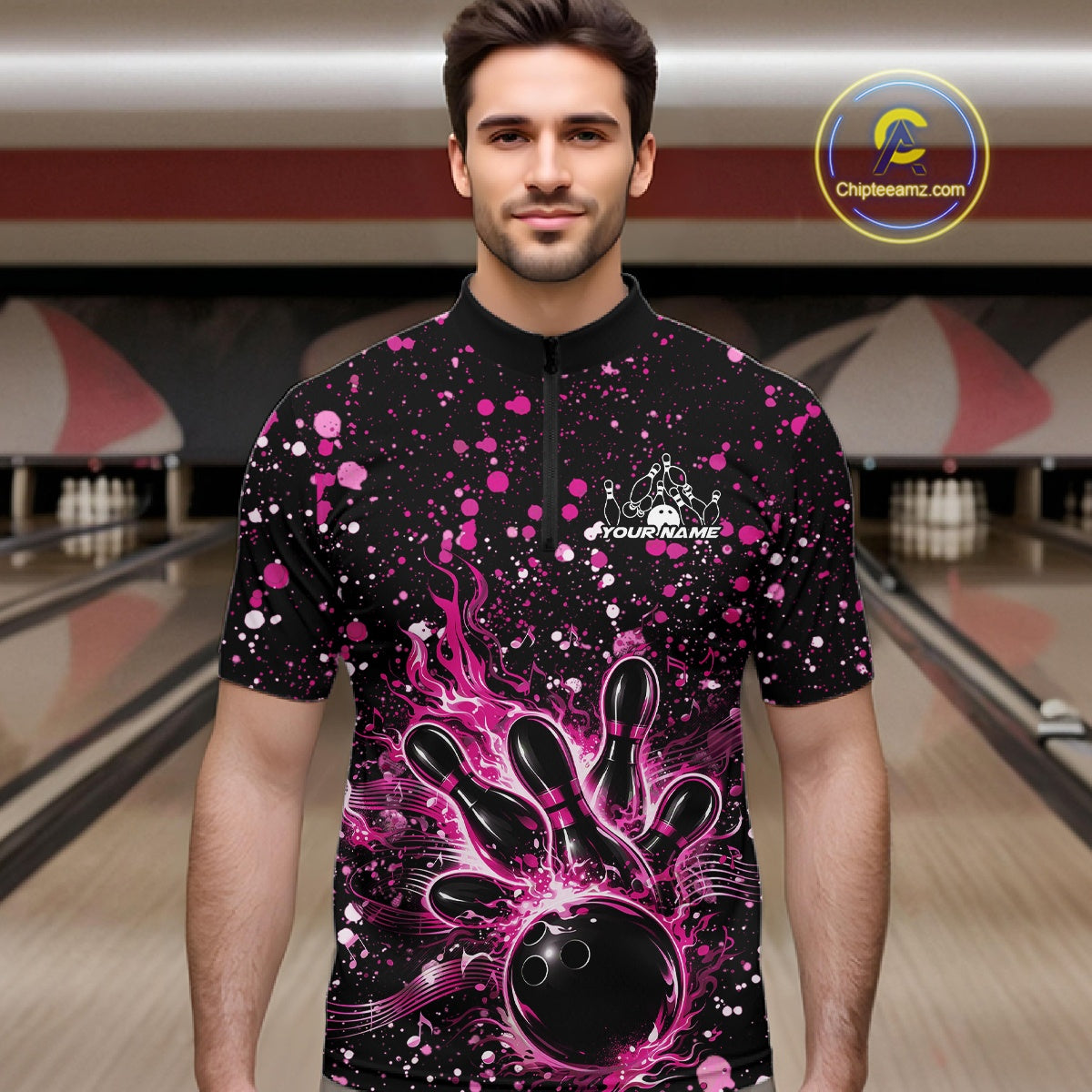 Male model wearing a black bowling quarter-zip shirt at the bowling lane with pink paint splatter accents and bowling strike graphics.