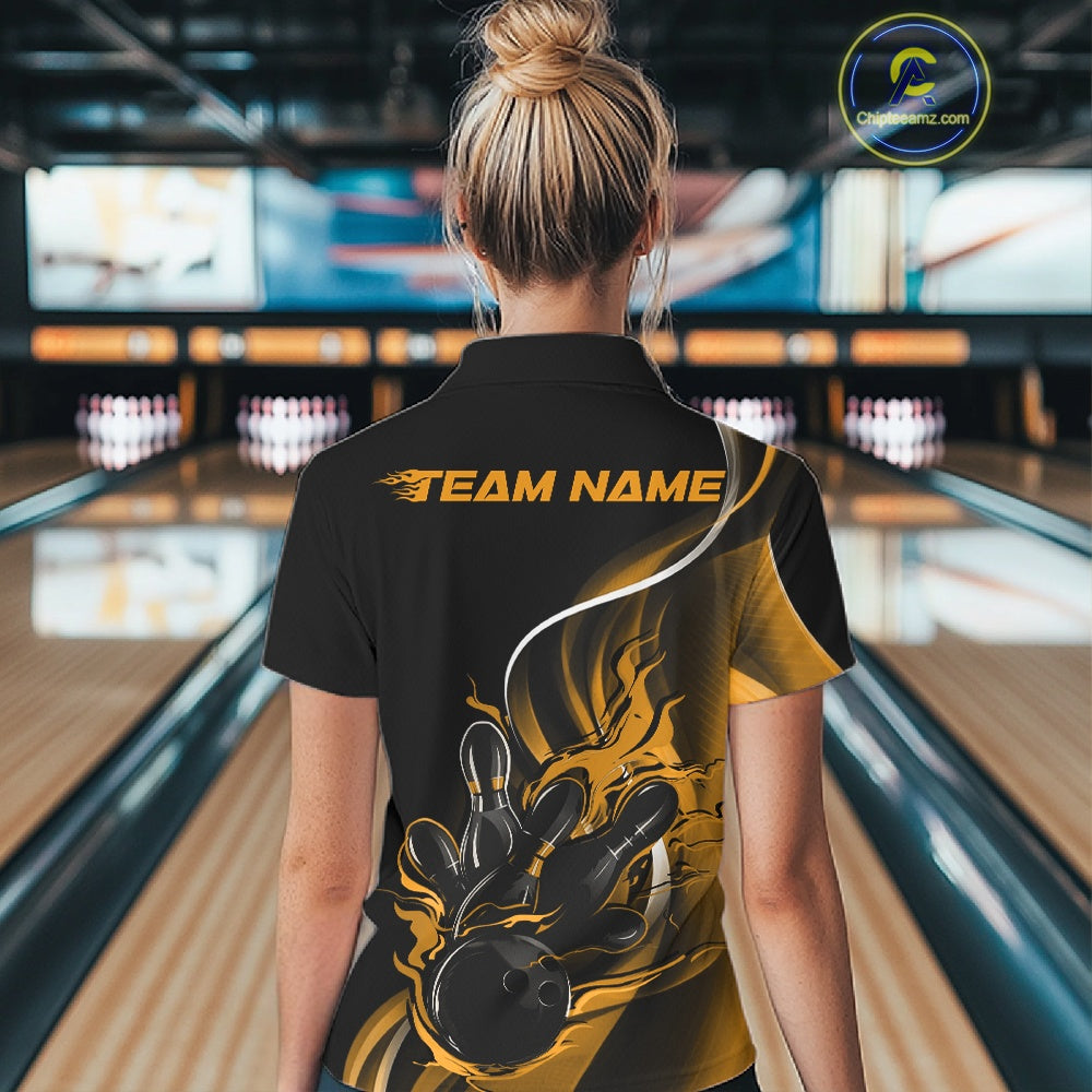 Female model back view at bowling venue wearing black and yellow polo shirt showcasing flame bowling ball striking pins in clean athletic style.