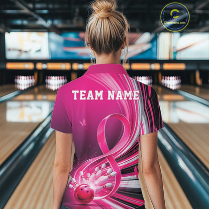 Back view of a female model wearing a pink bowling quarter zip with breast cancer awareness ribbons and bowling graphics