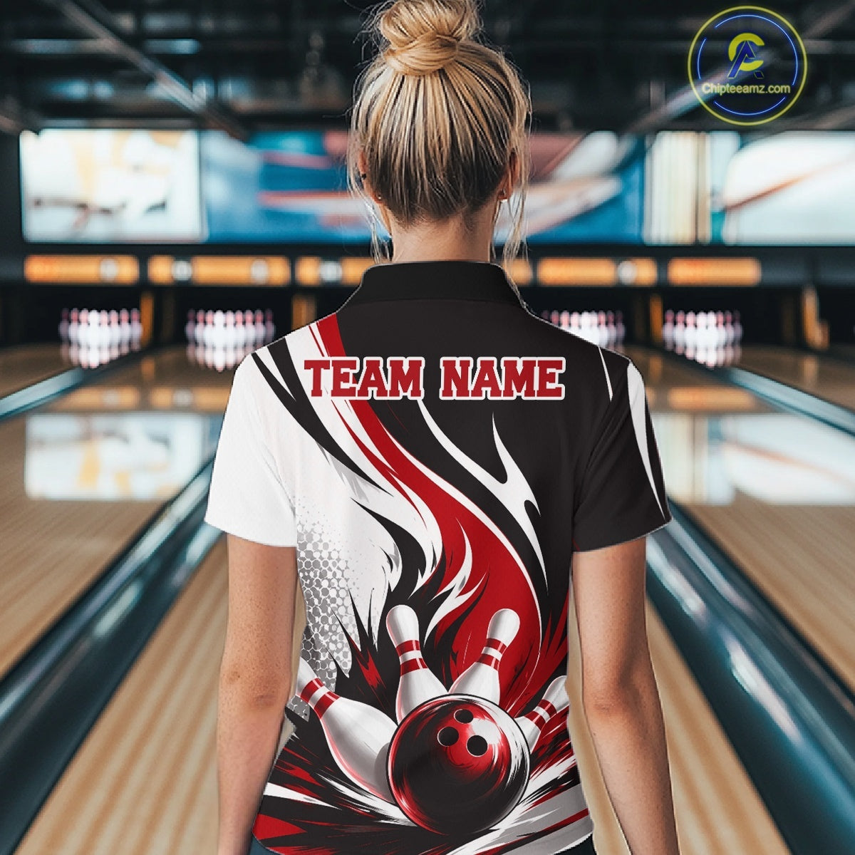 Back view of a female model wearing a white, black, and red bowling polo shirt showcasing a flaming bowling ball striking pins artwork in a bowling lane.