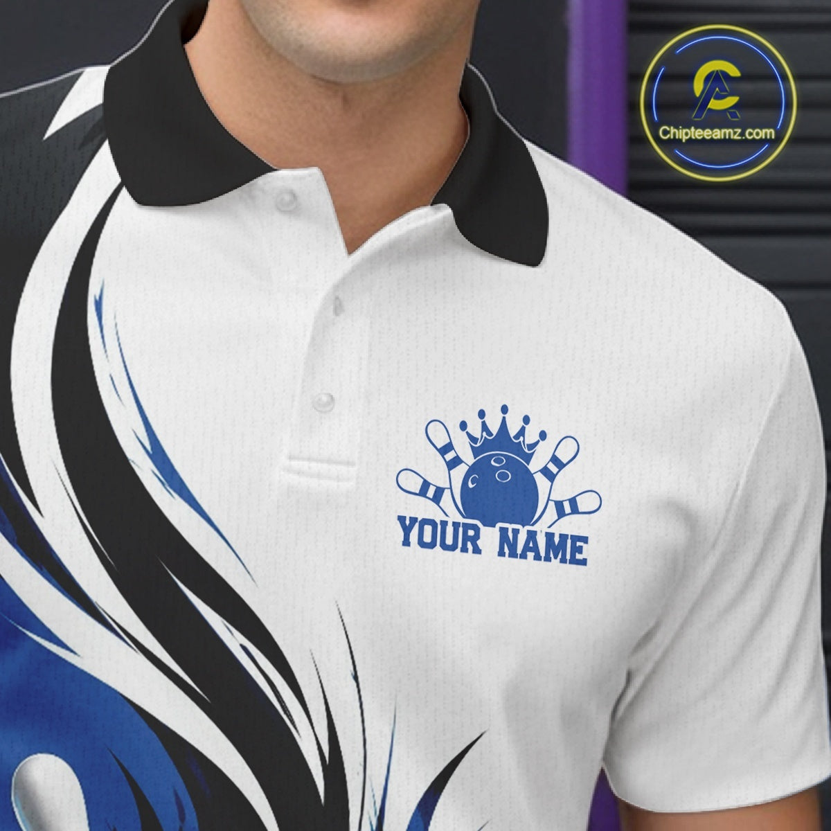 Close-up of the left chest on a white, black, and blue bowling polo shirt featuring a flaming bowling ball striking pins graphic.
