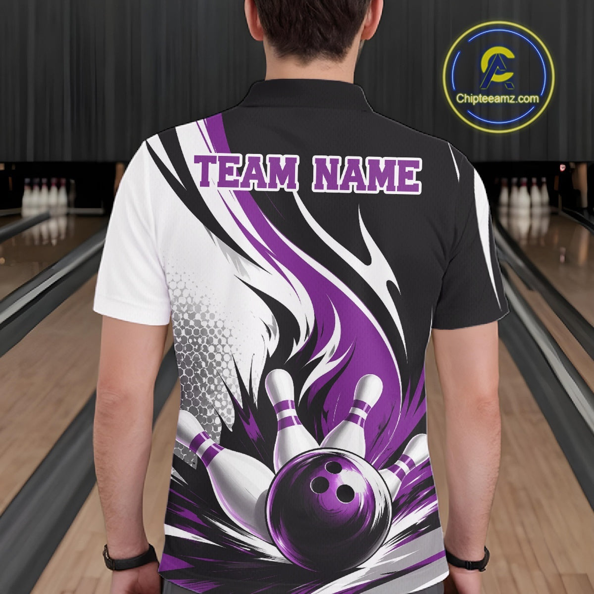 Back view of a male model wearing a white, black, and purple bowling polo shirt with a flaming bowling ball striking pins graphic inside a bowling lane.
