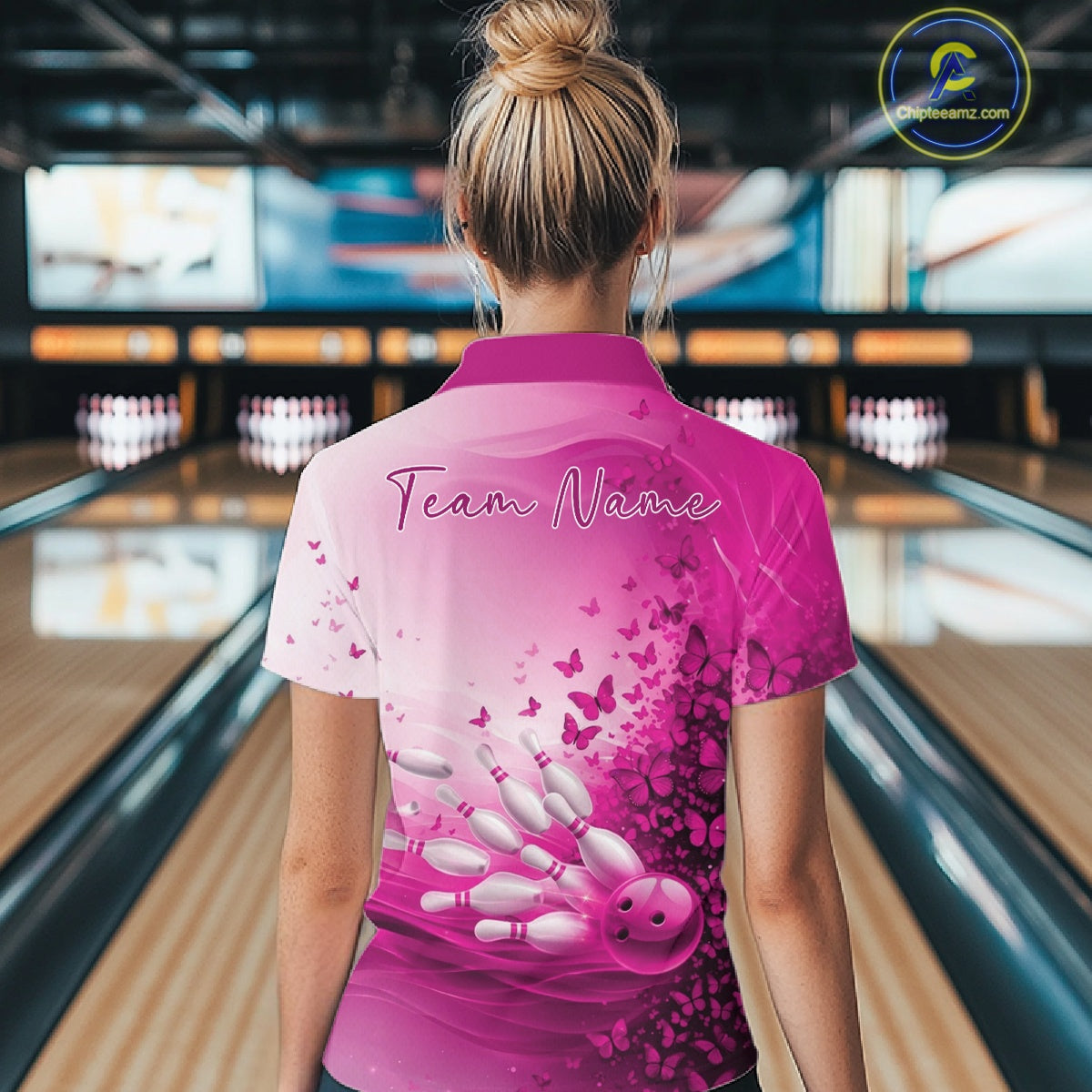 Back view of a female model in a white and pink bowling quarter zip with butterfly artwork and colorful bowling graphics