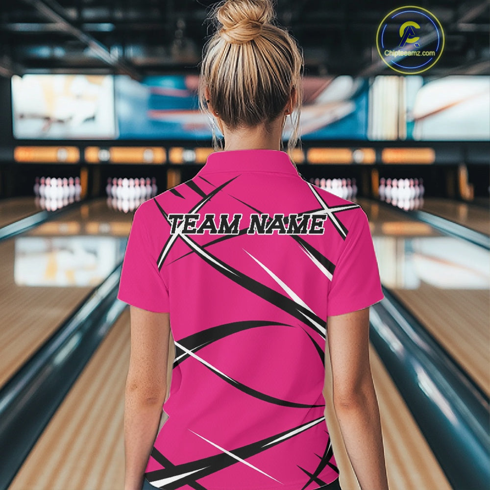 Back view of a female model wearing a pink, black, and white bowling polo shirt in a bowling alley