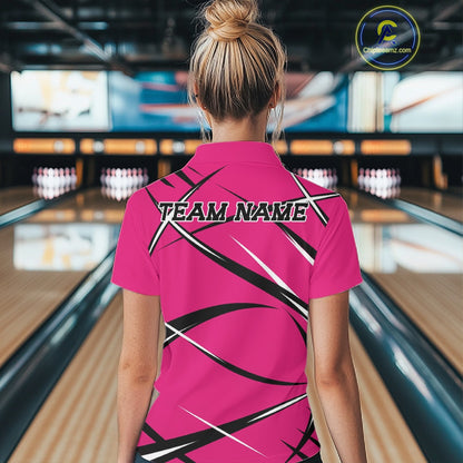 Back view of a female model wearing a pink, black, and white bowling polo shirt in a bowling alley