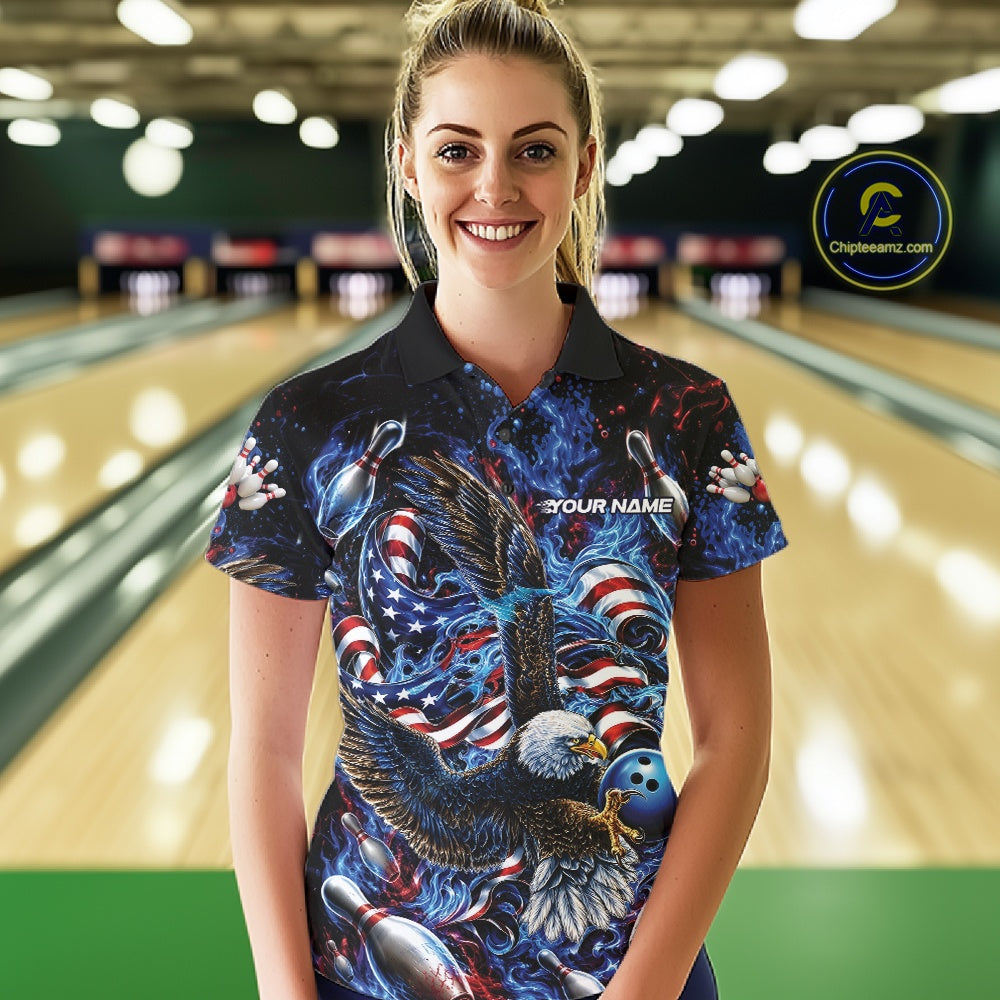 Female model front view at the bowling lane wearing a bowling polo shirt with flaming eagle graphics, blue bowling ball, American flag, and blue flames.