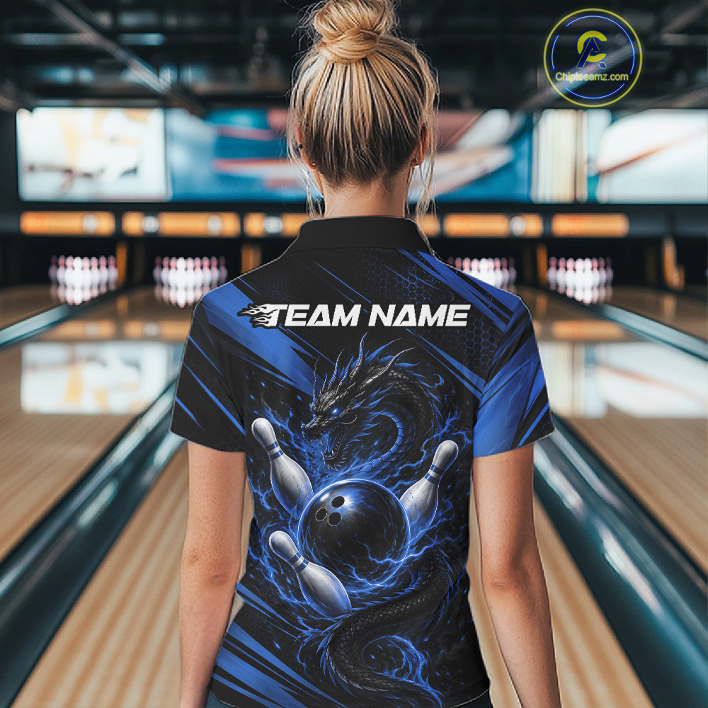 A woman viewed from behind wearing a custom bowling-themed short-sleeve polo shirt with a blue and black dragon and bowling ball graphic, standing in a bowling alley. The shirt features a customizable 'TEAM NAME' print on the back.