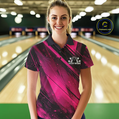 Woman wearing a pink and black bowling shirt with a logo in a bowling alley.