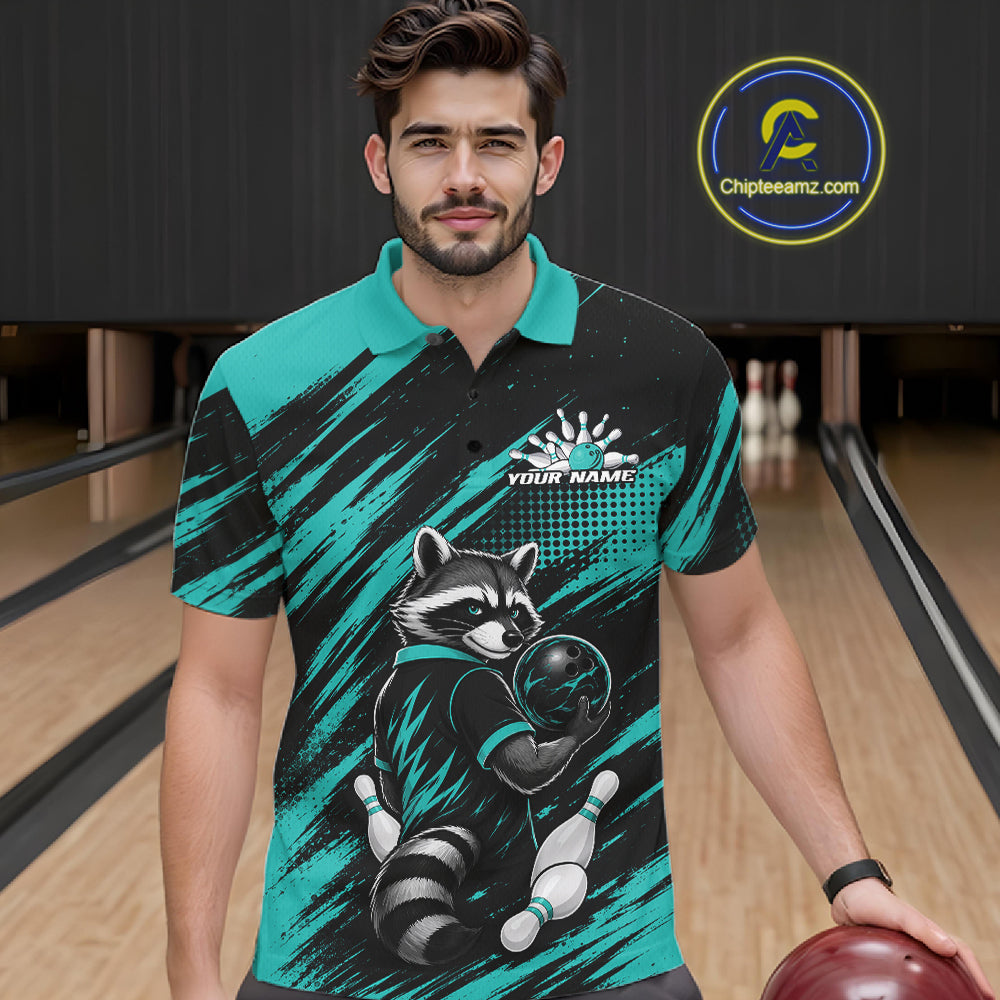 A man wearing a custom bowlin polo shirt with a raccoon graphic and teal and black brushstroke patterns, standing in a bowling alley holding a bowling ball.