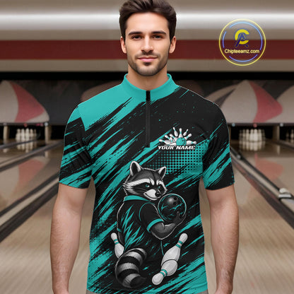 A man wearing a short-sleeve quarter-zip bowling jersey with a raccoon graphic, set against a blurred bowling alley background. The jersey features a teal and black brushstroke pattern with a raccoon holding a bowling ball 