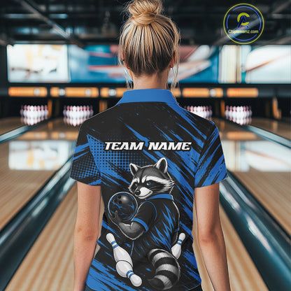 A woman viewed from behind wearing a short-sleeve bowling shirt with a raccoon graphic and 'TEAM NAME' text on the back, standing in a bowling alley.
