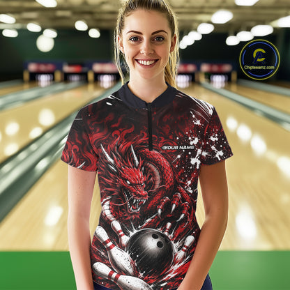 Person wearing a red dragon-themed bowling shirt in a bowling alley.