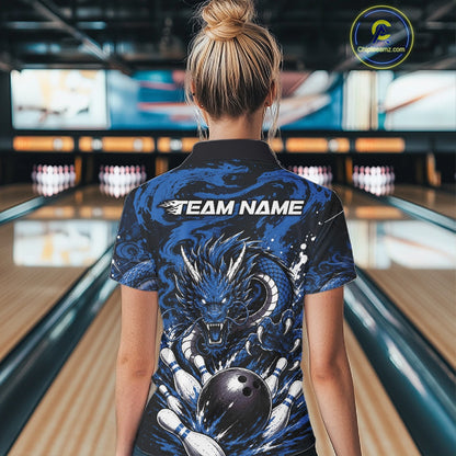 Person wearing a blue and black bowling shirt with a dragon design in a bowling alley.