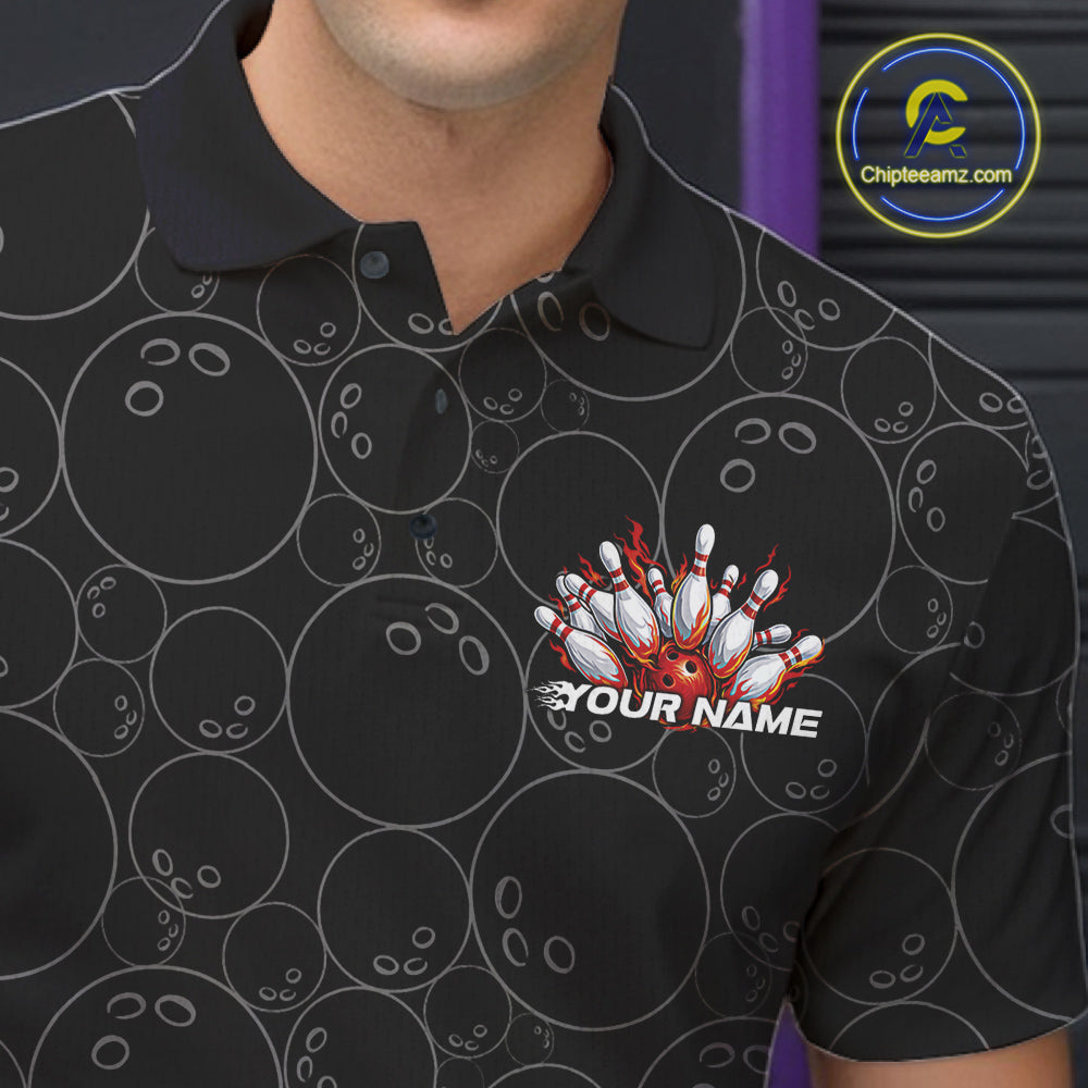 Close-up view of the left chest of a black bowling polo shirt showing bowling ball pattern with vibrant red flames rising and detailed bowling artwork.