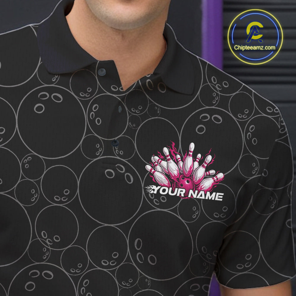Close-up view of the left chest of a black bowling polo shirt showing bowling ball pattern with vibrant pink flames rising and detailed bowling artwork.