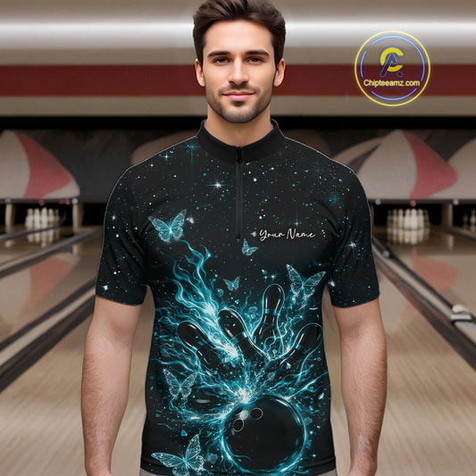 Male model in a black and turquoise blue bowling quarter-zip shirt at the lane with glowing butterfly strike graphics.