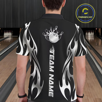 Male model seen from the back in a bowling lane wearing a black polo shirt featuring a silver metal tribal flame bowling ball striking pins in a dynamic motion design.